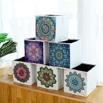 Caja decorativa con diseño de mandala asociado al Punto De Diamante, exhibida sobre una mesa de madera.