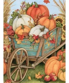 Carretilla de madera azul llena de calabazas naranjas y blancas rodeadas de hojas de otoño, manzanas, girasoles, espigas de trigo y un cielo azul, representando el Cuadro Carretilla Calabazas Diamond Painting.
