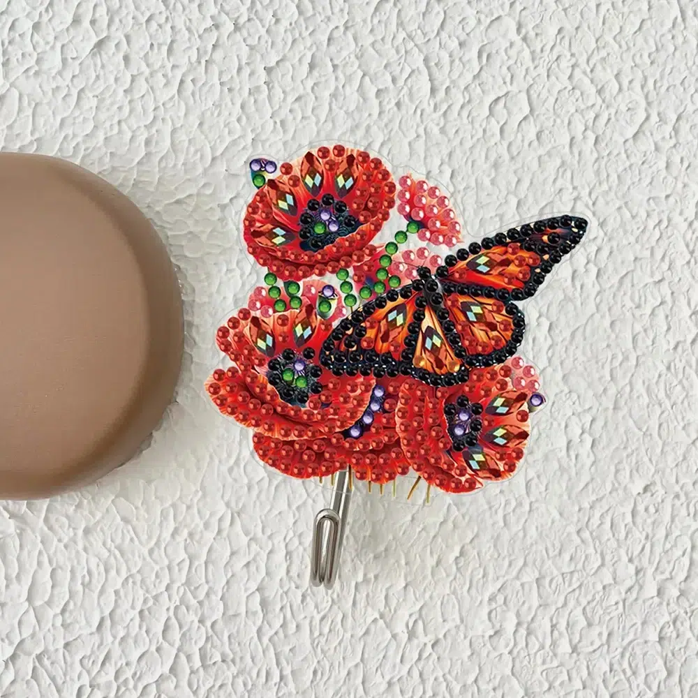 Cuelga llaves de pared hecho a mano con diamantes en forma de mariposa y flores rojas.